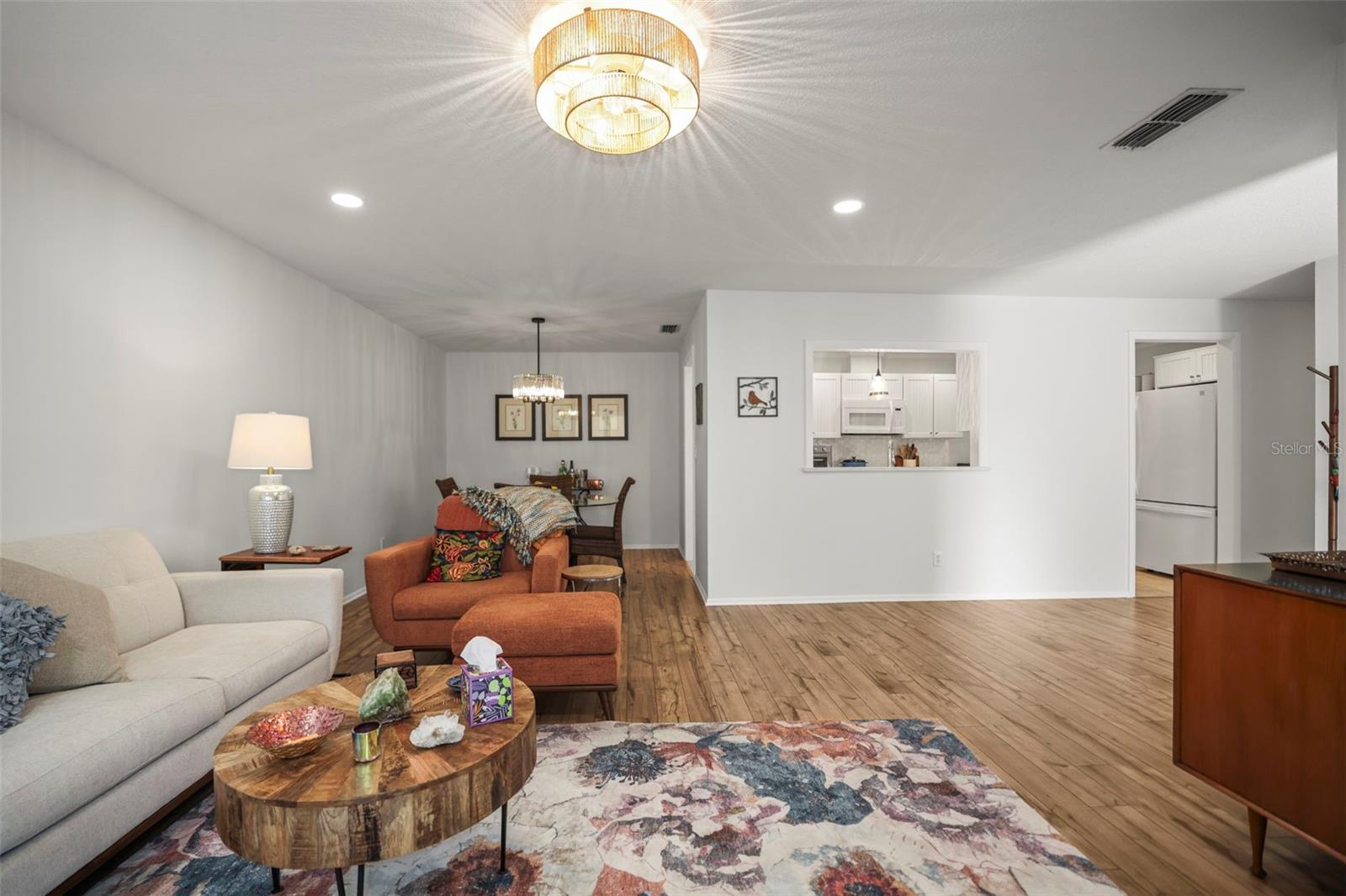 Living room open to dining room and showing pass through to the kitchen with engineered hardwood flooring