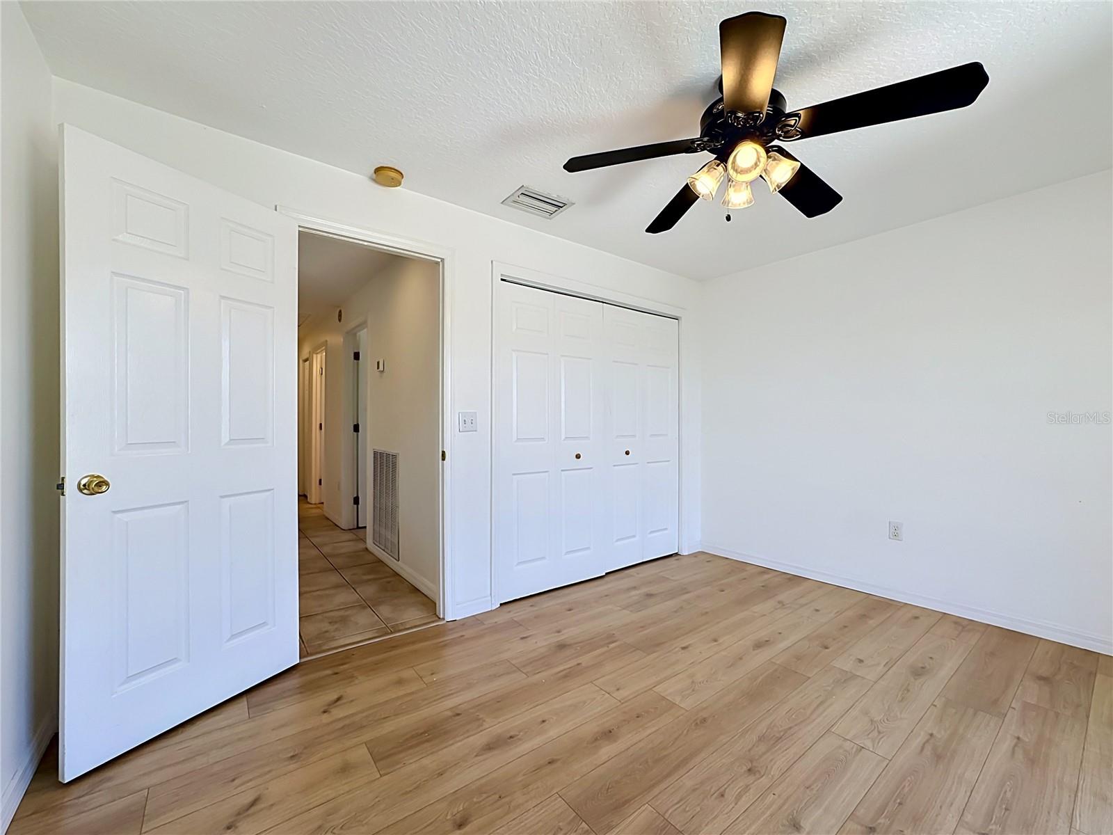 Guest bedroom with ceiling fan and large closet