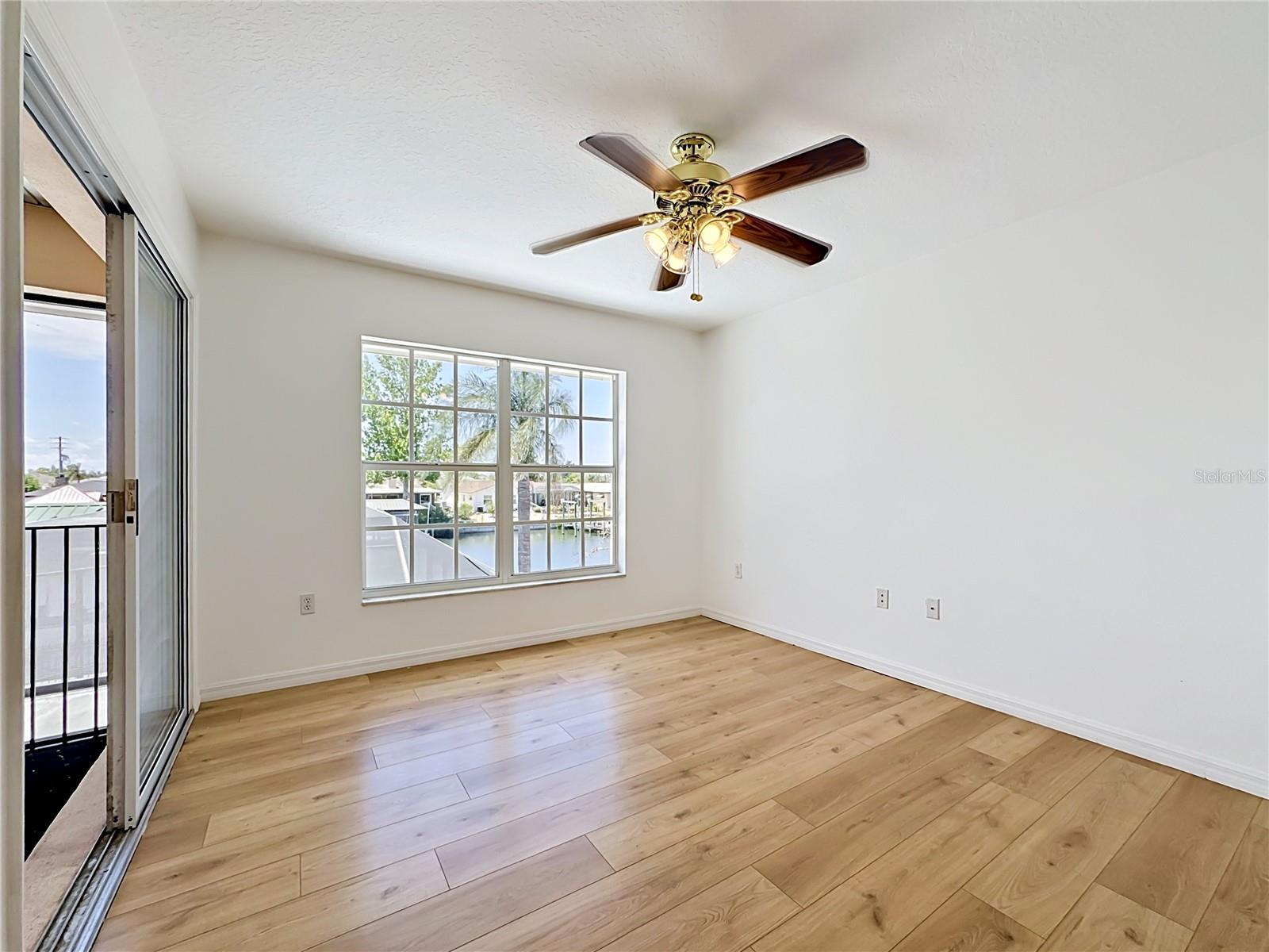 Bright guest bedroom with views and ceiling fan