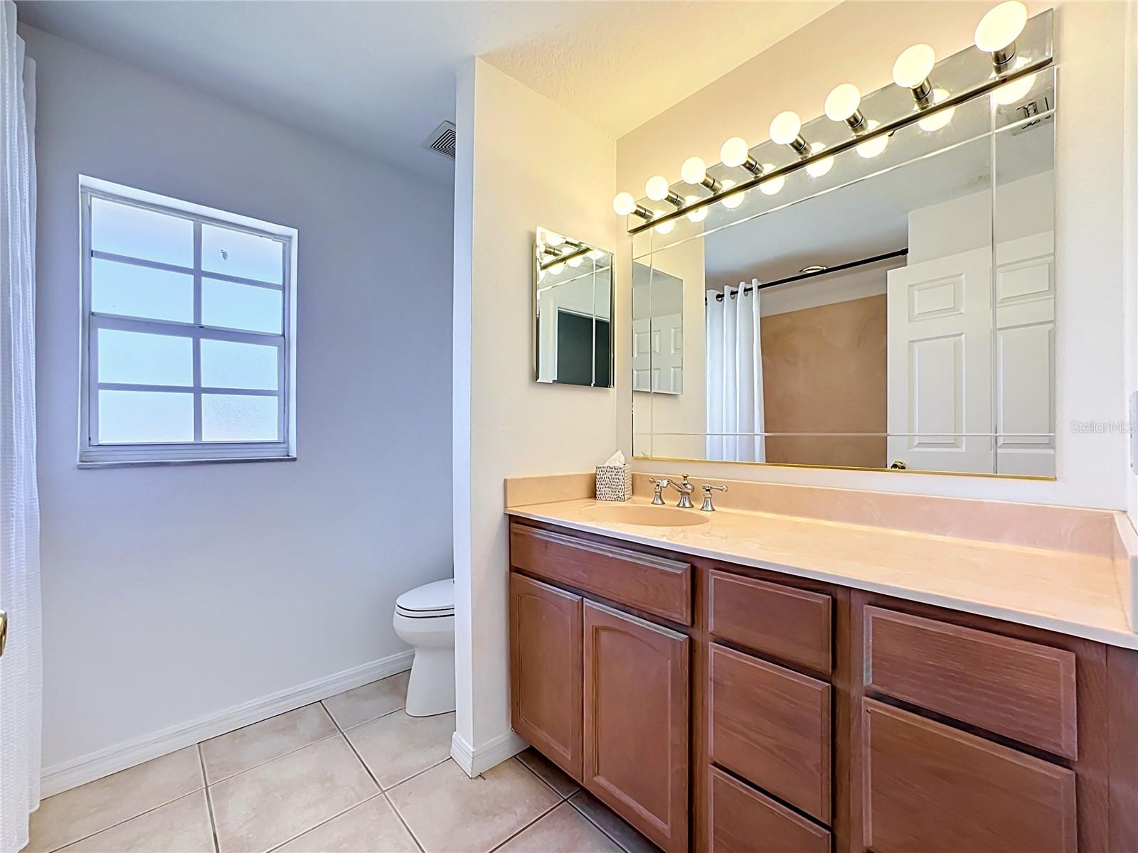 Upper guest bath with large vanity and window for natural light