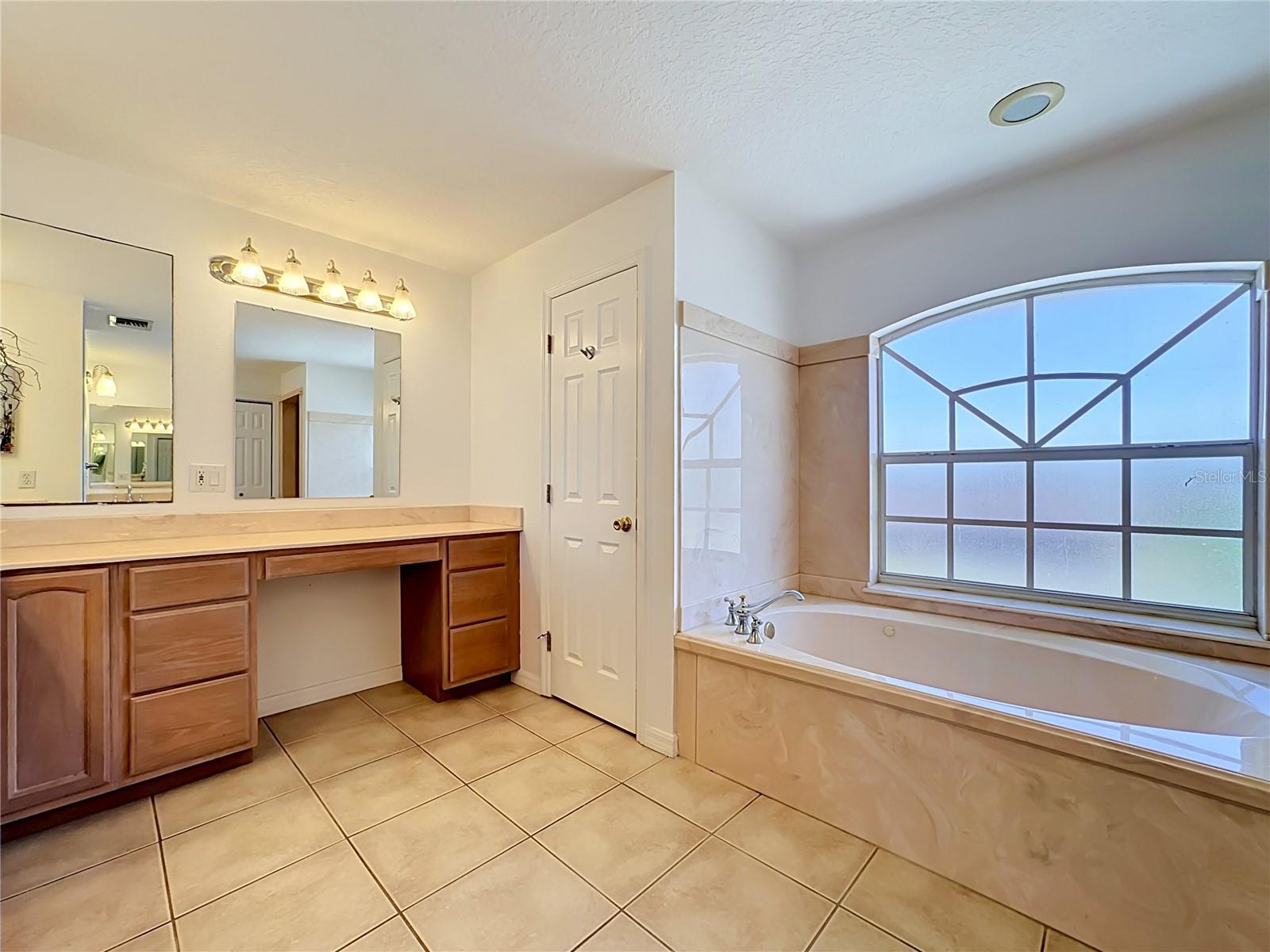 Garden soaking tub framed by oversized windows
