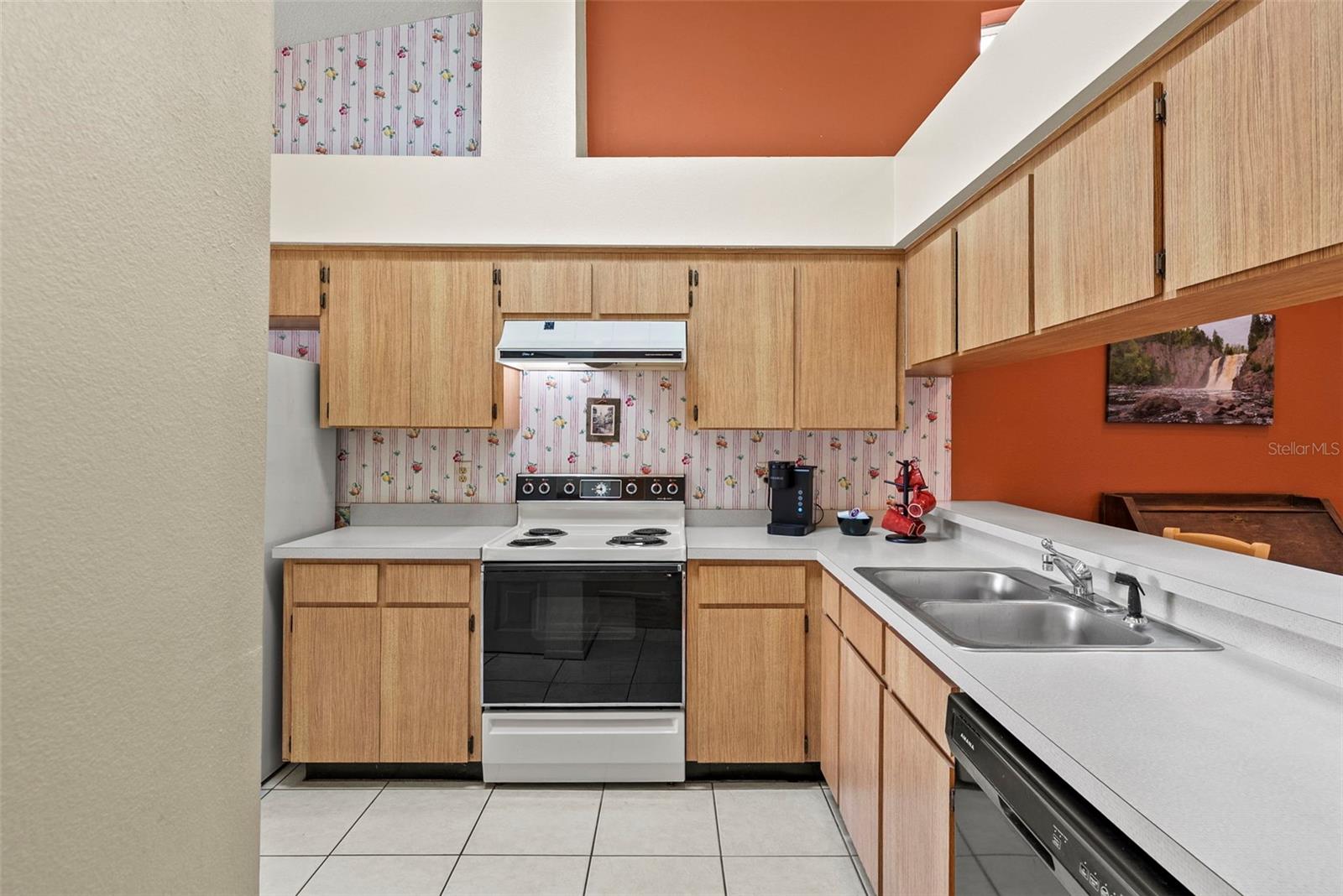 Functional kitchen with ample cabinetry, tile flooring, and convenient sink workspace.
