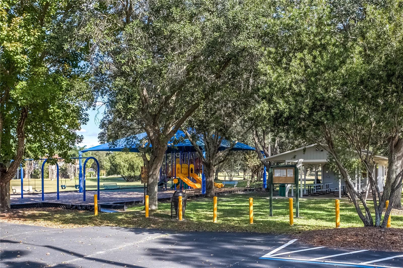 Community playground with shaded seating and parking nearby.
