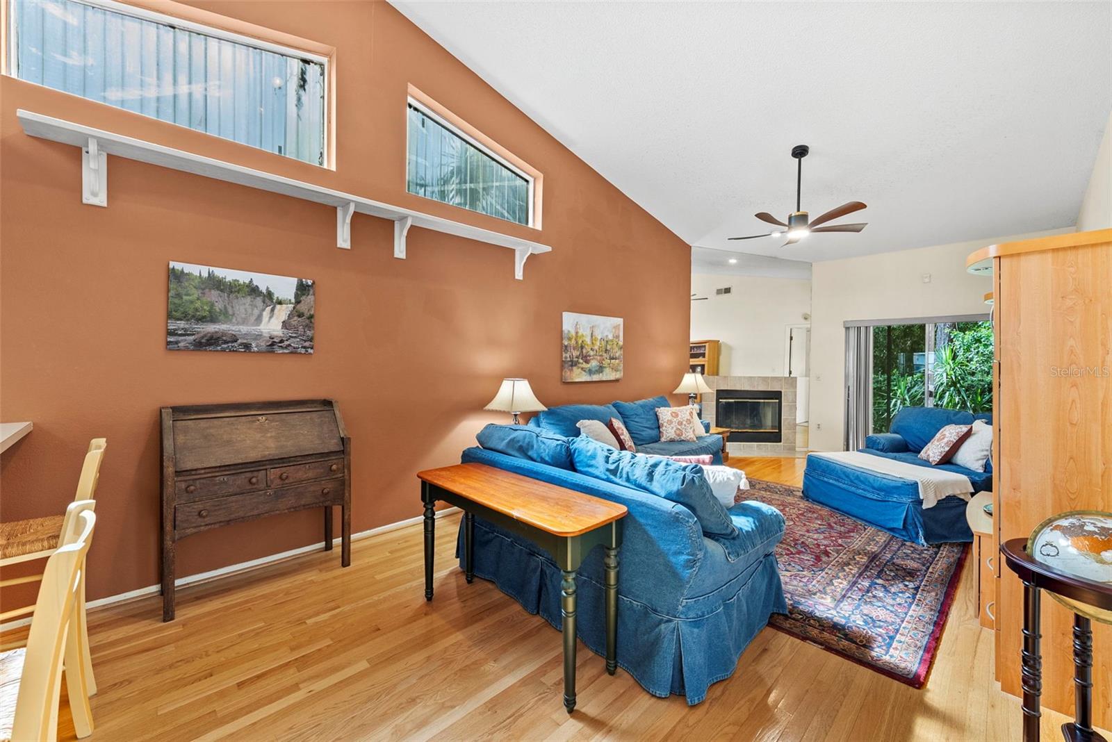 Spacious living room with vaulted ceilings, wood flooring, and sliding glass doors.