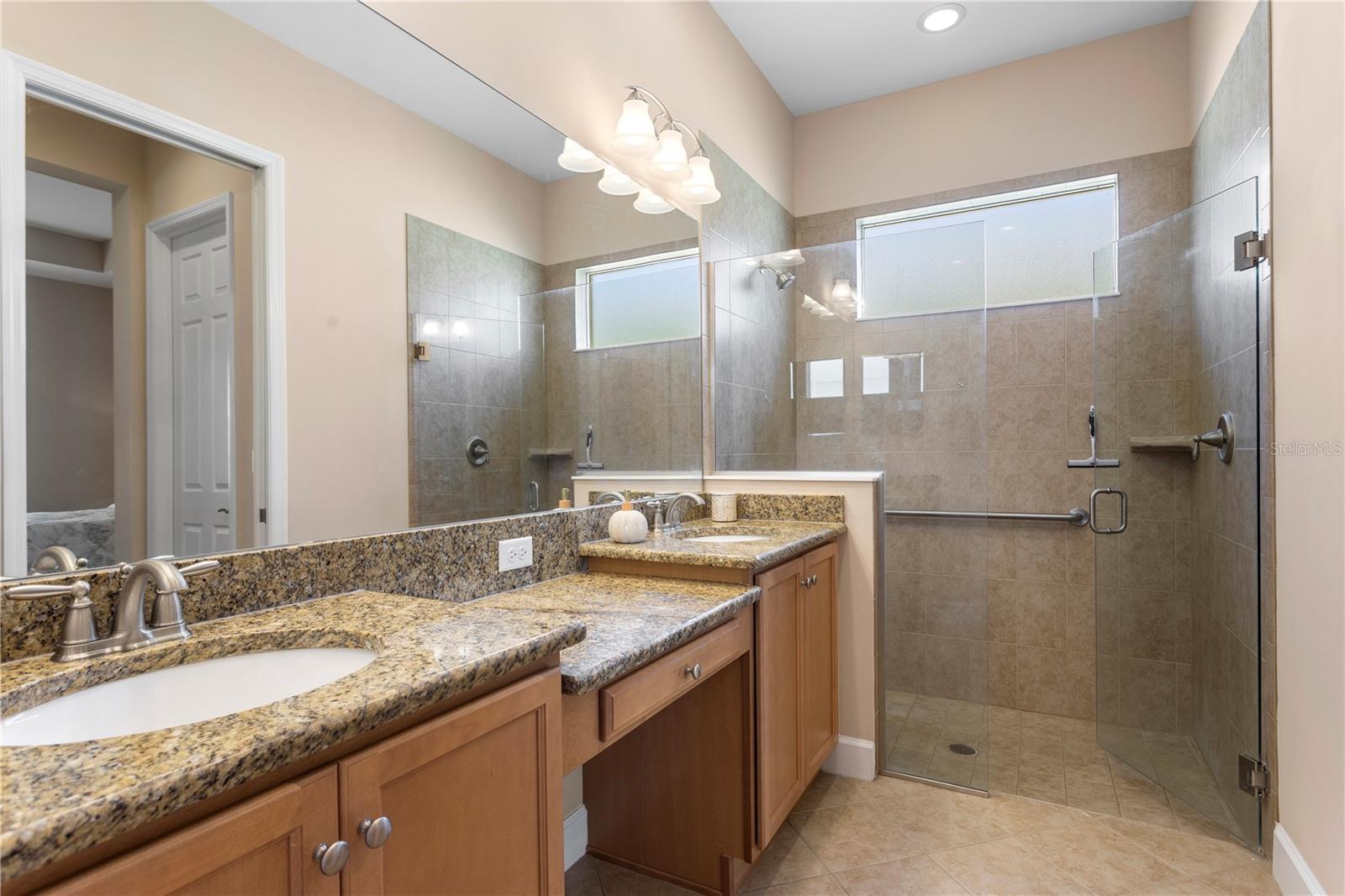 Primary Bedroom en suite with dual sinks and vanitiy. Walk in shower