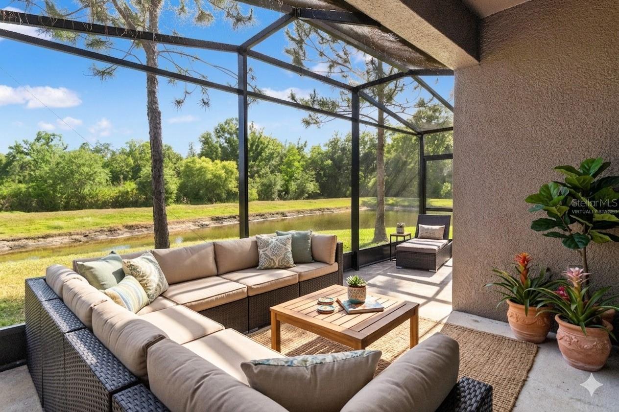 Virtually Staged just off the kitchen and dining area is the extender Screened lanai with a view of the pond out back