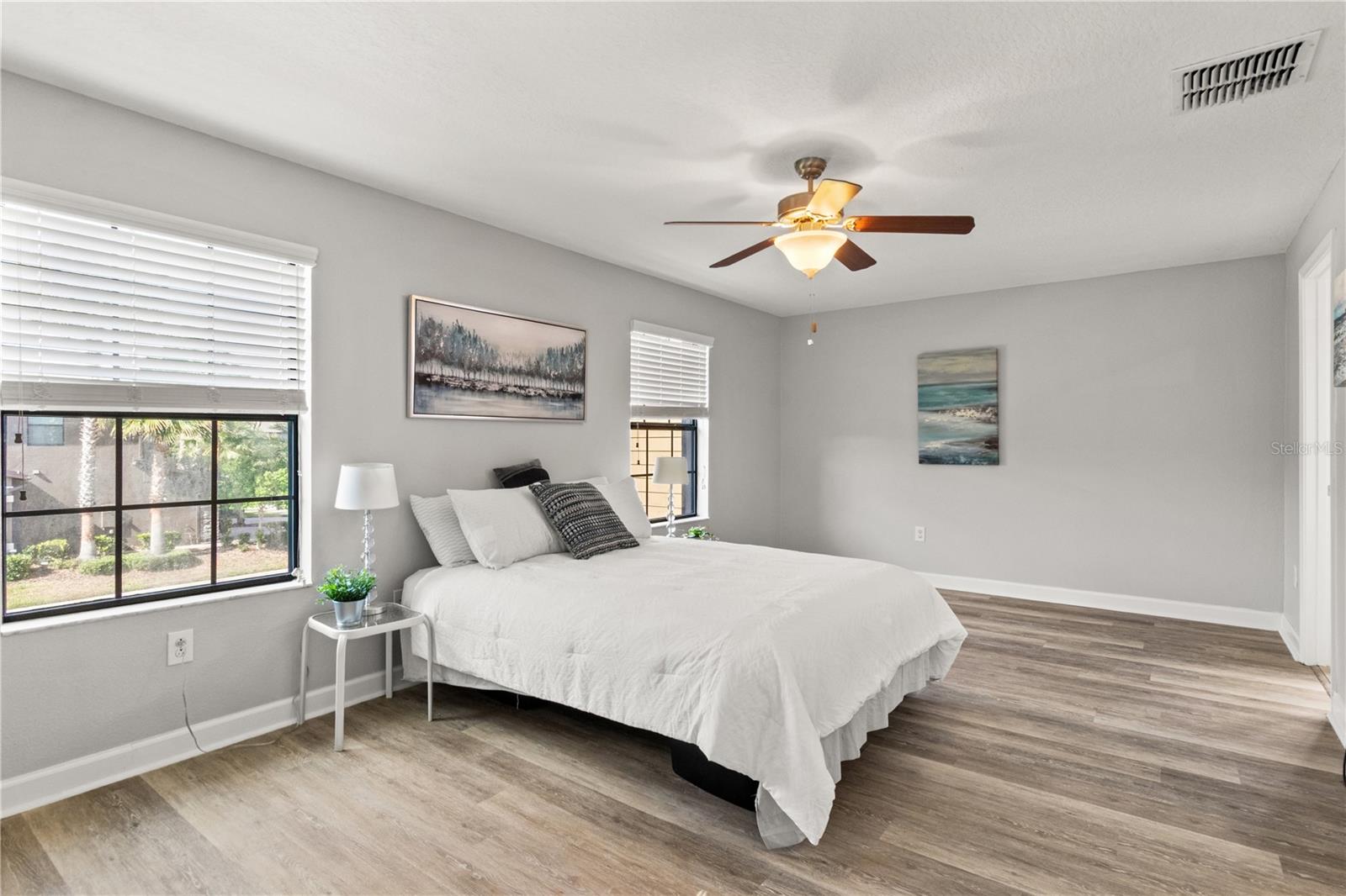 Primary Bedroom with room for multiple dresses, a king sized bed and end tables