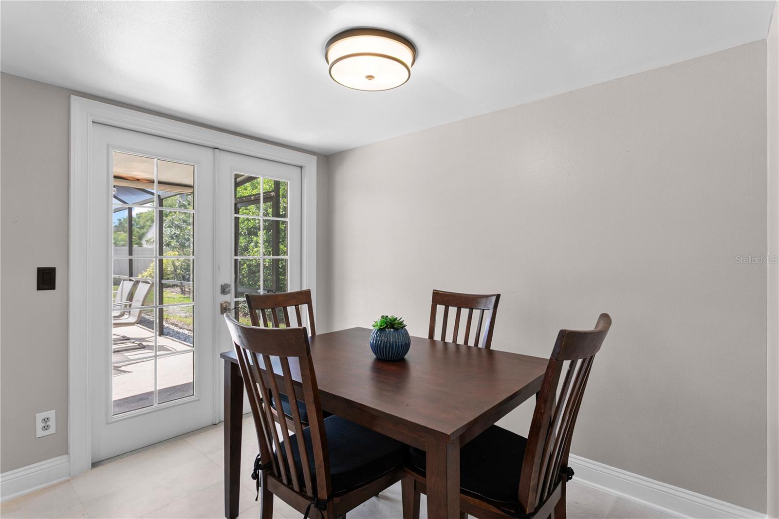Casual dining area with french doors leading to the lanai and saltwater pool