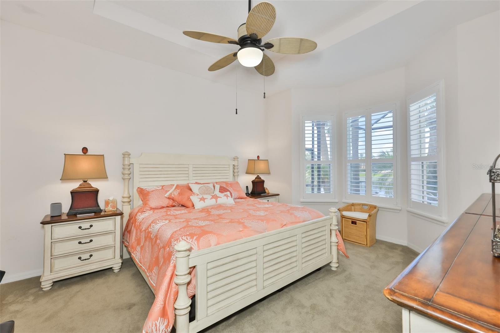 The primary bedroom is large with plantation shutters (as in the rest of the home), a trey ceiling and custom fan make this a relaxing room.