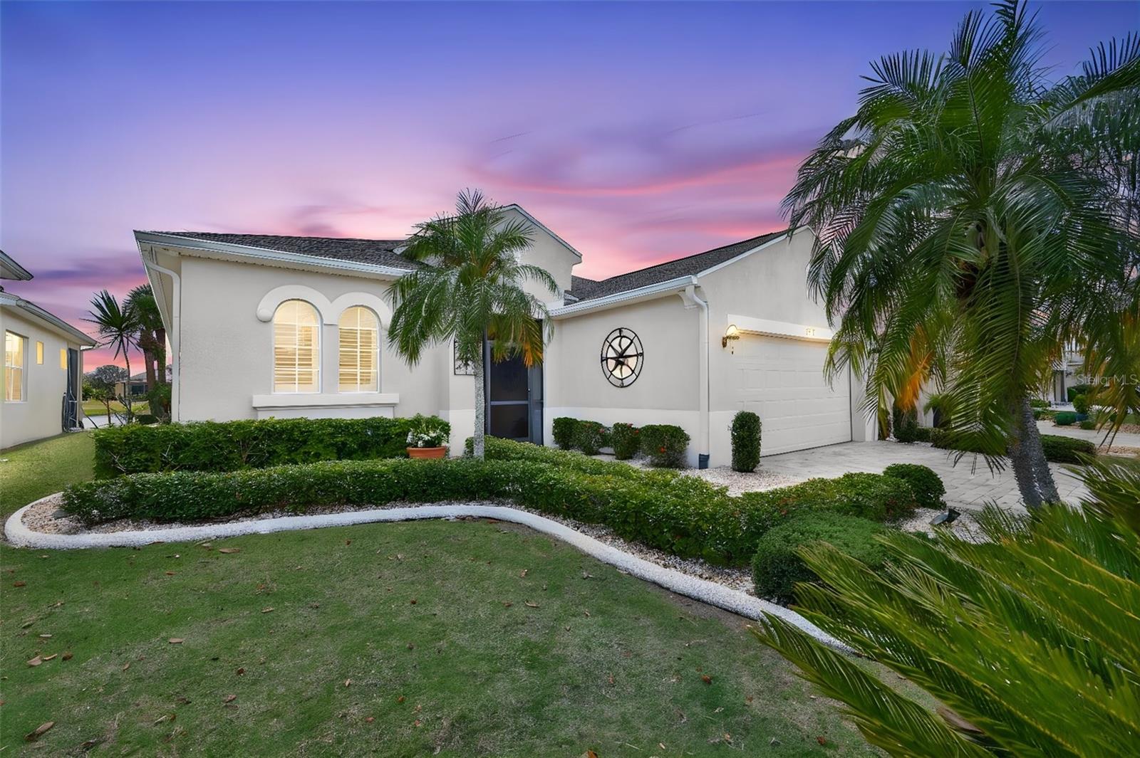 Beautifully maintained Floridian landscaping, front screened porch and arched entrance.