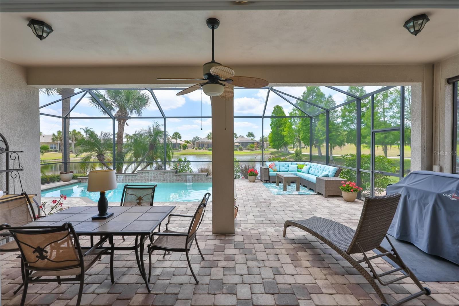 Custom pavered, covered, screened lanai with both water front and a golf course view (Hole #3).