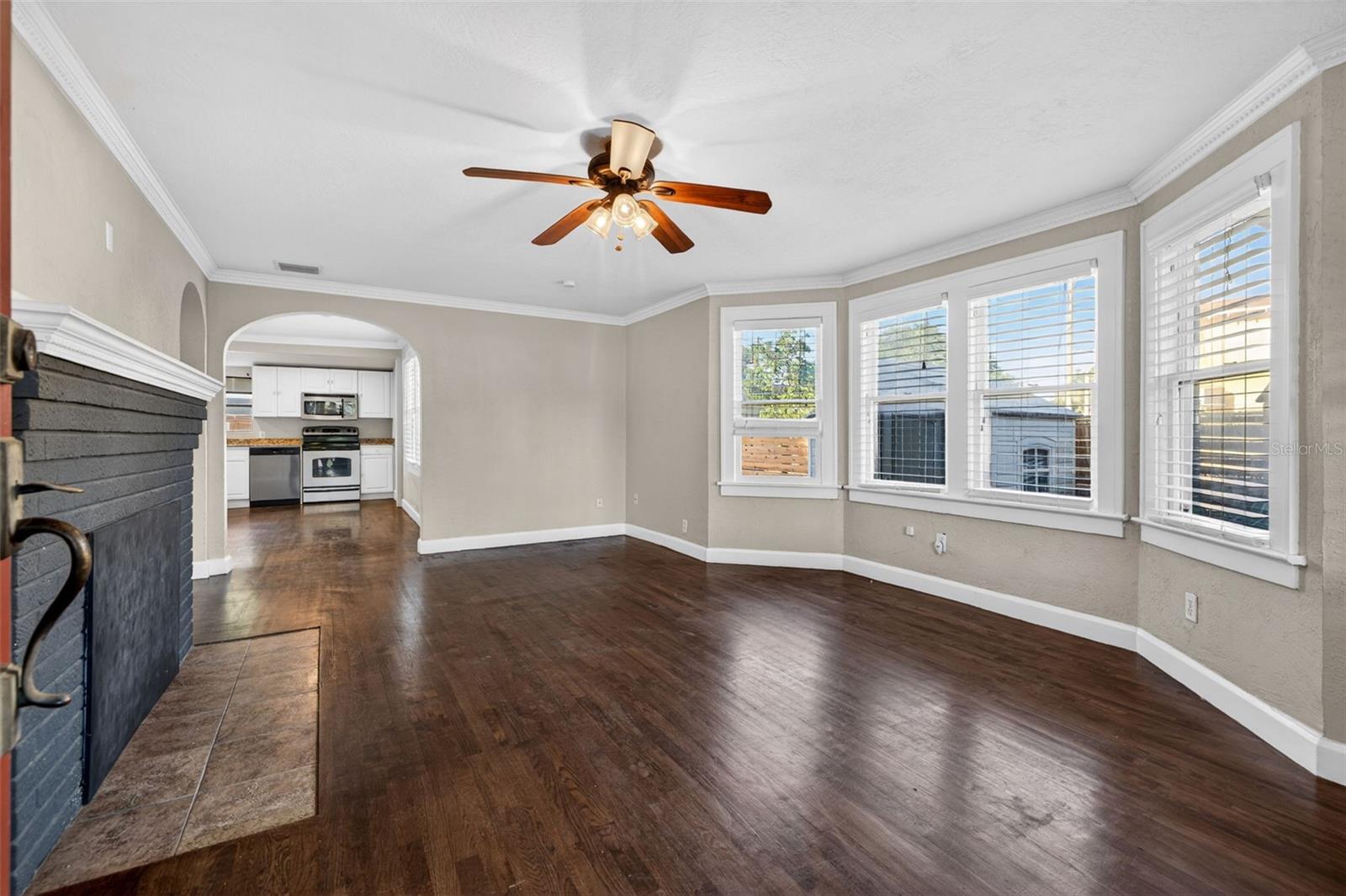 Beautiful natural sunlight living room with crown moulding and arched doorways.