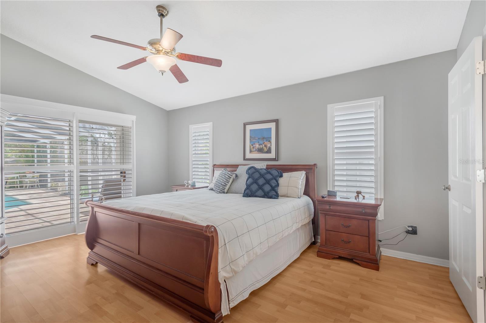 The spacious primary suite at the front of the home is a true retreat with private pool access, a large walk-in closet, catherdral ceilings and an updated en-suite bathroom.