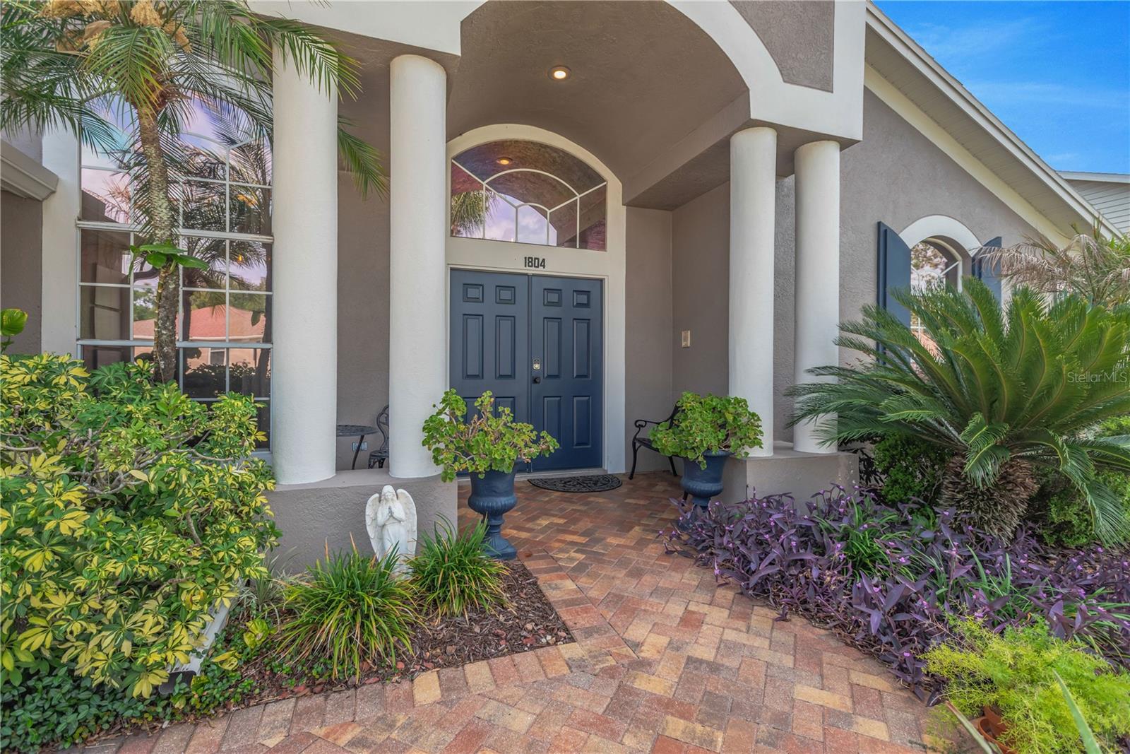 From the moment you arrive, the lush tropical landscaping, inviting front porch, and exceptional curb appeal set the tone for what awaits inside.
