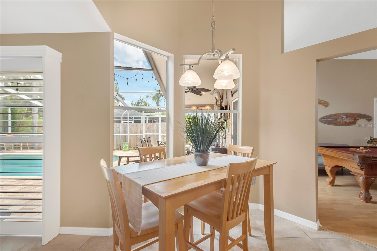 The sunny breakfast nook offers relaxing views of the screened lanai and sparkling pool, creating the perfect spot to start your day.