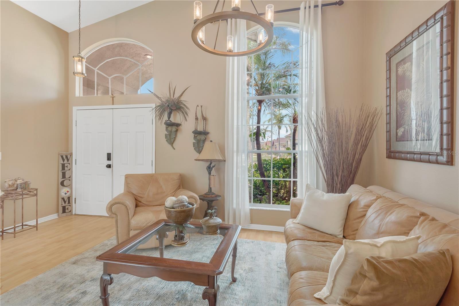 The dramatic front arched floor-to-ceiling window has been professionally tinted to help reduce sun exposure, and all window treatments will convey to the buyers.
