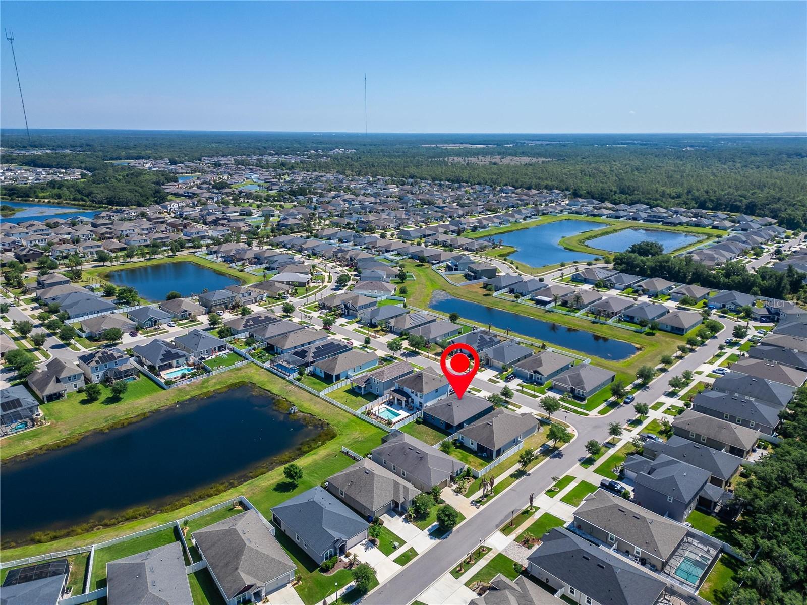Aerial views showcase the home’s peaceful setting surrounded by ponds and natural greenery.