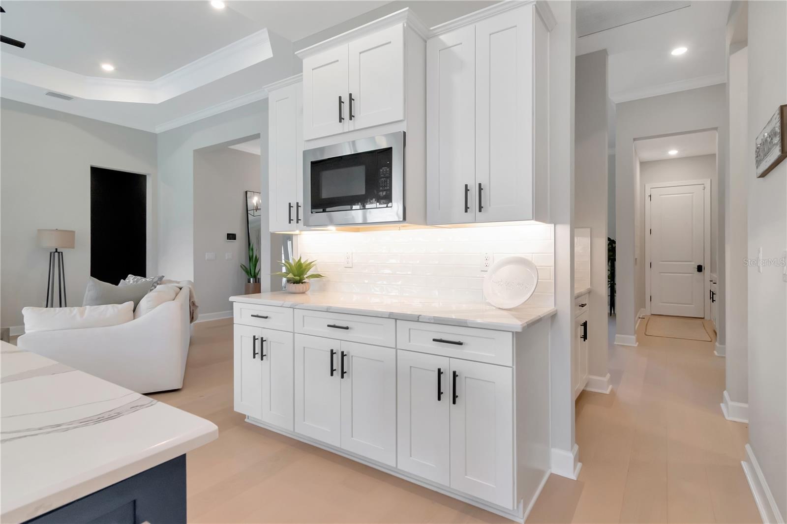 Gourmet Kitchen featuring Monogram luxury appliances, custom lighting, double ovens, expansive island AND a dry bar with full Butler's Pantry