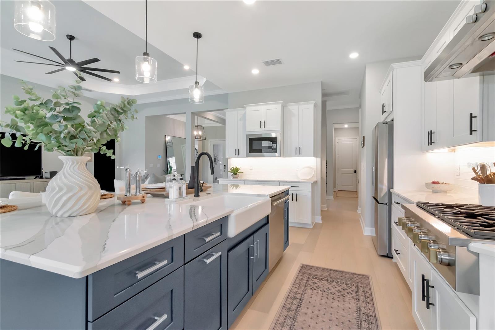 Gourmet Kitchen featuring Monogram luxury appliances, custom lighting, double ovens, expansive island AND a dry bar with full Butler's Pantry