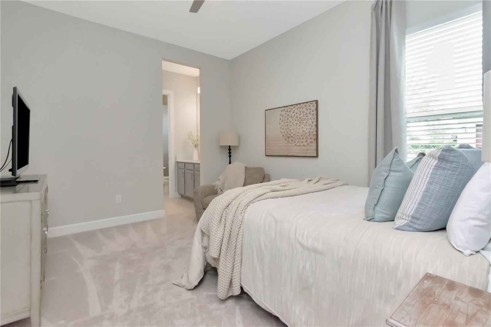 Bedroom 2 with shared Bathroom featuring private, dual vanities.