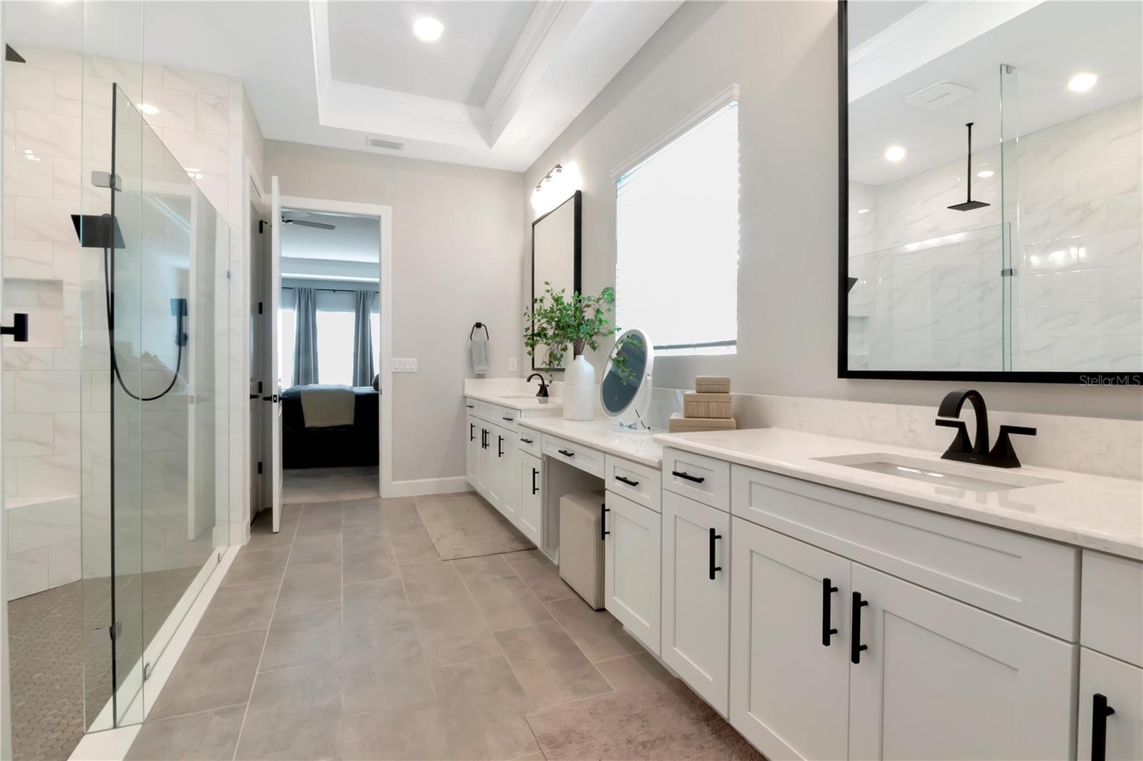 Primary Ensuite featuring endless, dual vanities, luxurious shower with dual showerheads and a custom walk in closet