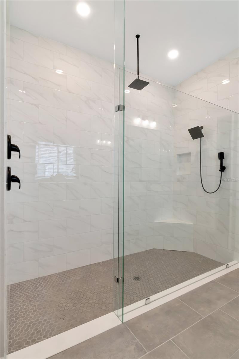 Glass Enclosed, doorless Primary shower with waterfall showerhead feature.