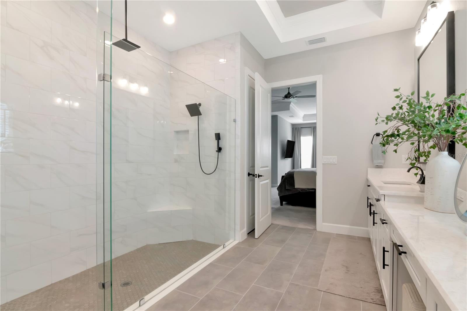 Primary Ensuite featuring endless, dual vanities, luxurious shower with dual showerheads and a custom walk in closet