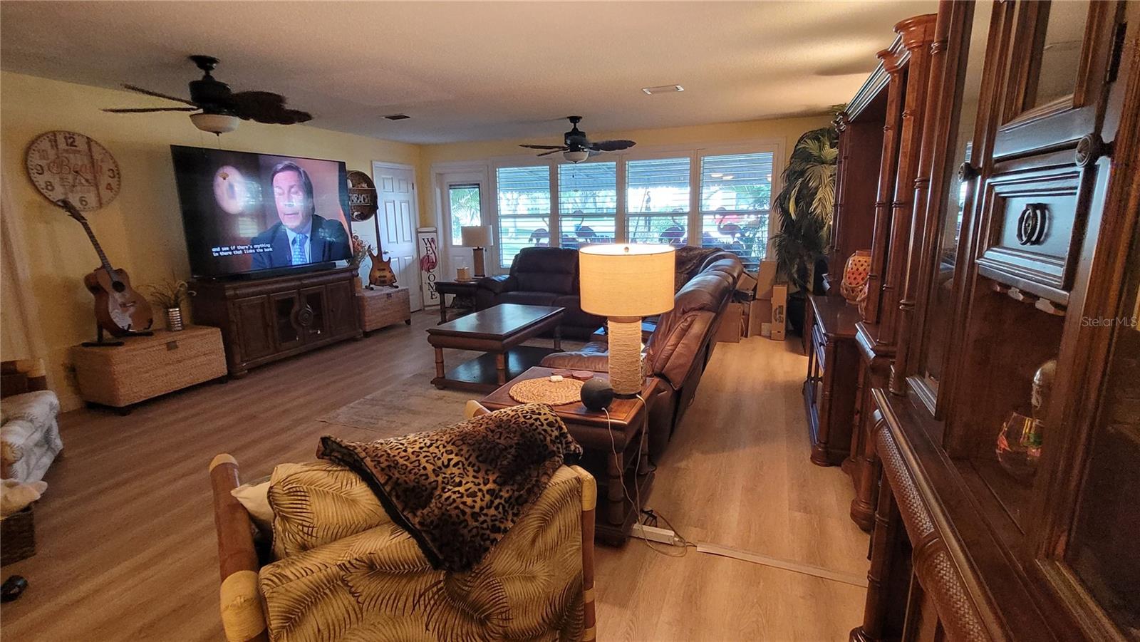Spacious living room has luxury plank vinyl floors, impact windows and plantation shutters.