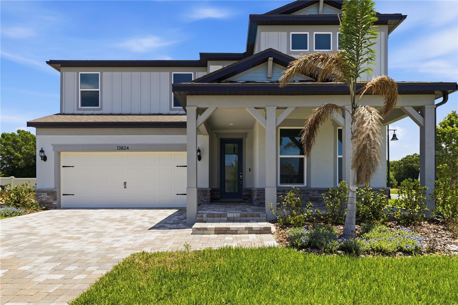 Welcoming exterior with a covered entry, stone accents, and a bright Florida feel.