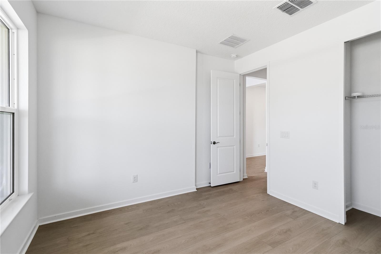 Spacious bedroom with a simple layout, bright walls, and flexible furniture options.