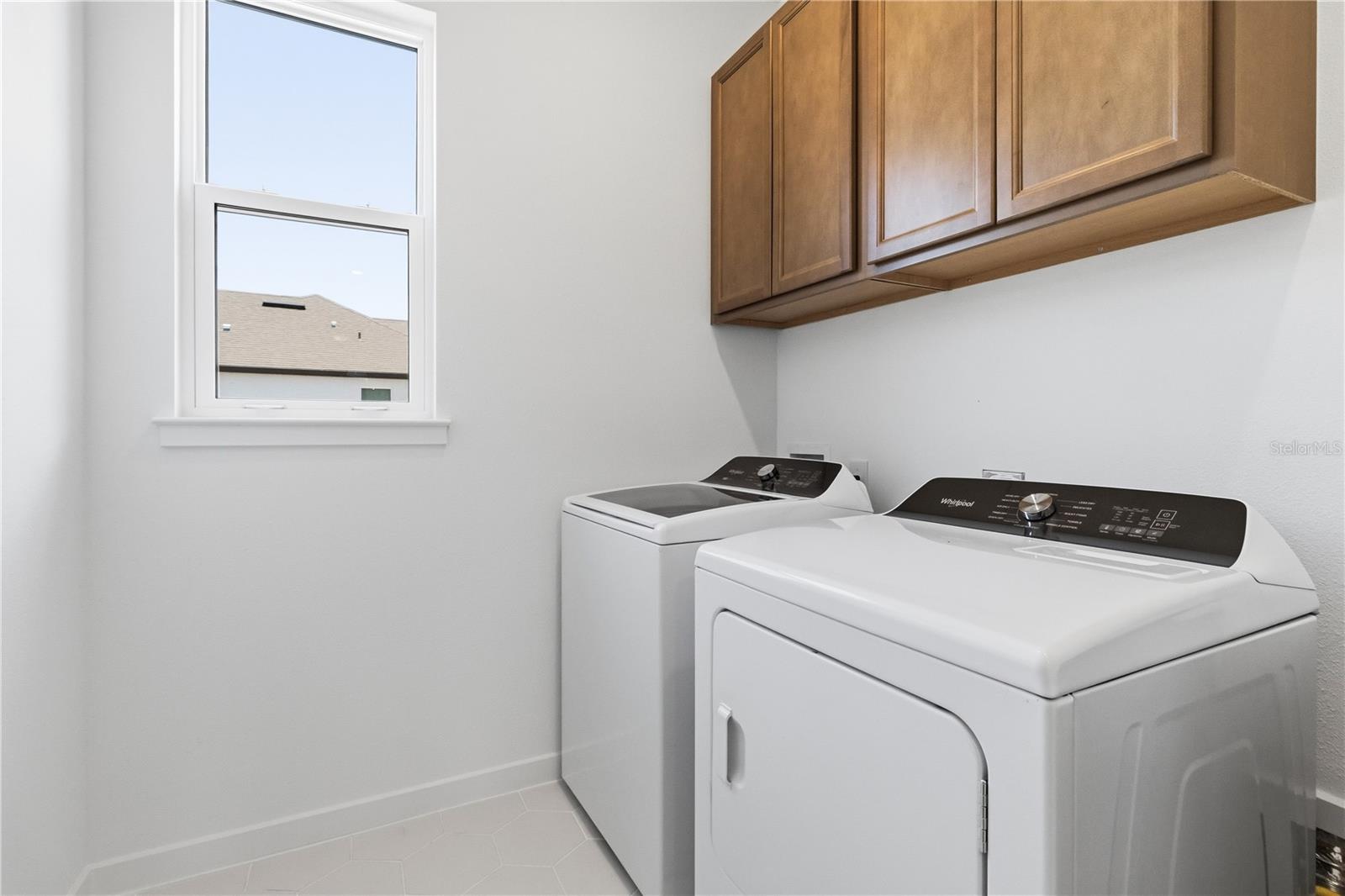 Convenient laundry room with built in cabinetry and everyday function.