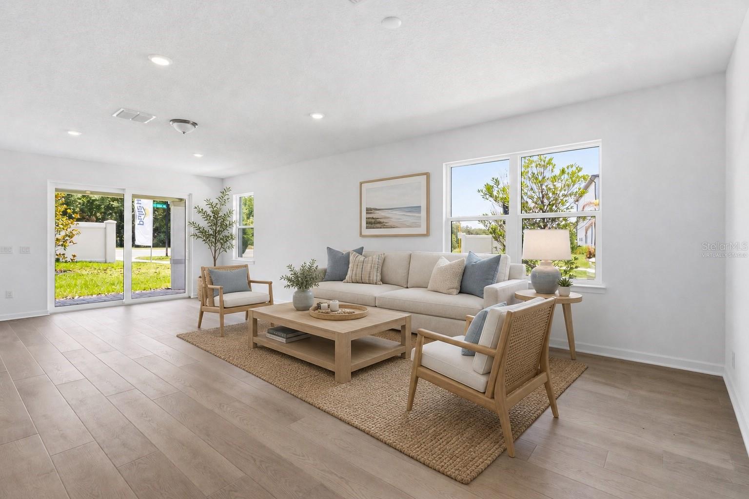 Virtually staged living space with warm wood look floors and an easy open layout.