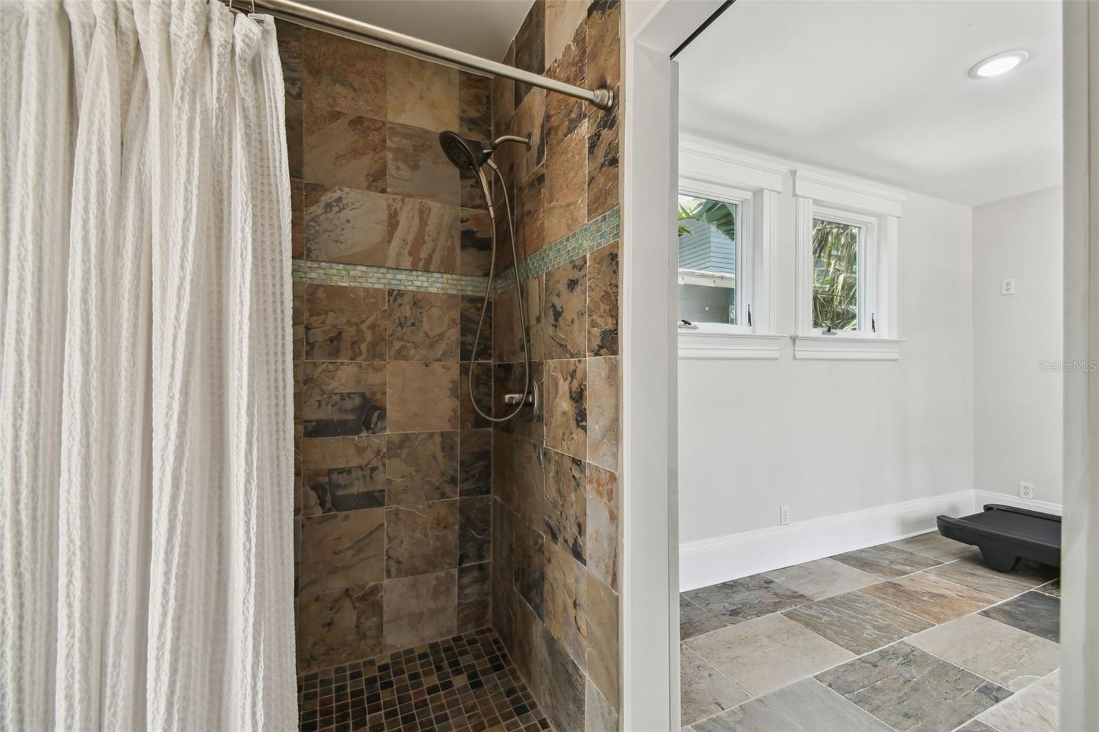 Gym area bathroom shower.  Opening to the right into the gym closes off with a barn door.