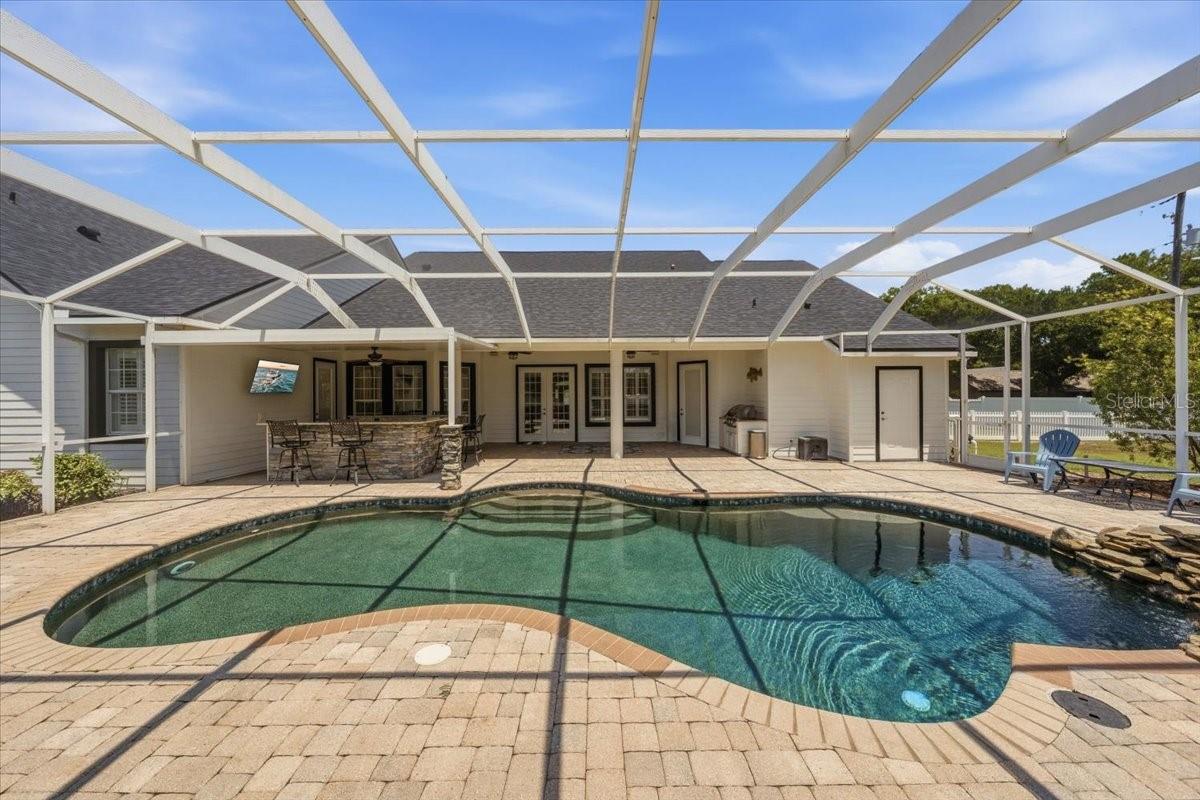Seamless indoor-outdoor living! This expansive screened enclosure offers plenty of space for lounging and dining, providing a perfect backdrop for Florida’s year-round sunshine.