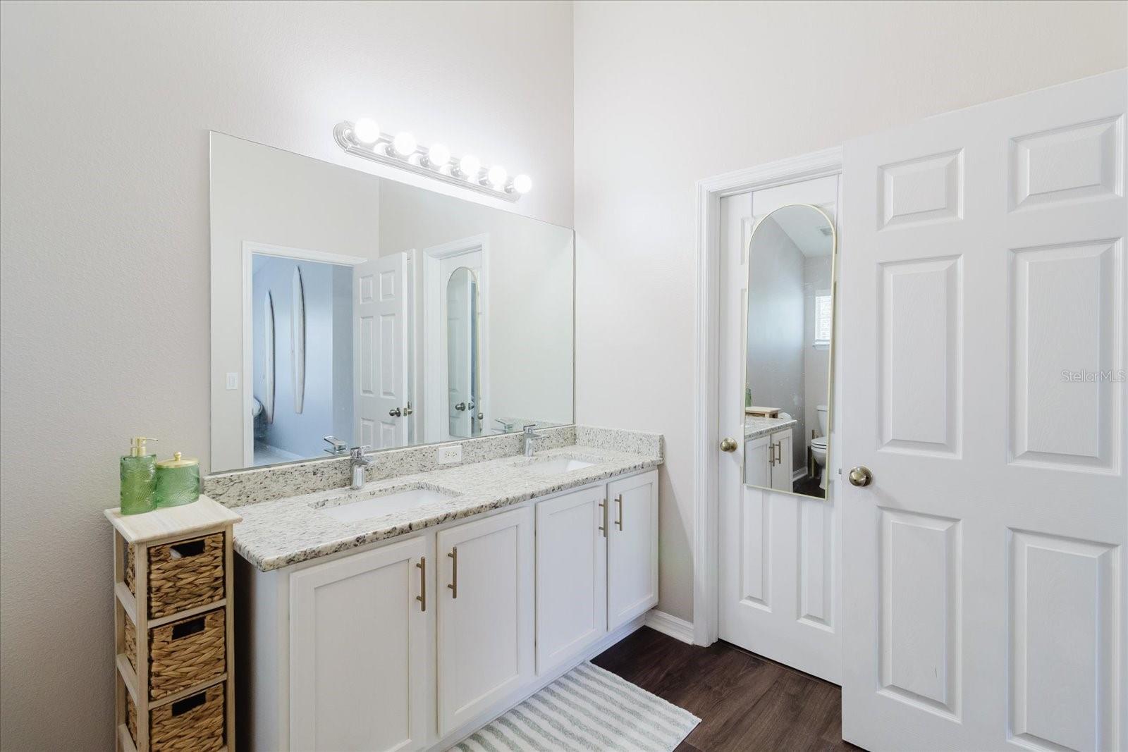 Primary Ensuite Bathroom With Double Vanity With Granite Counters & Luxury Vinyl Floors