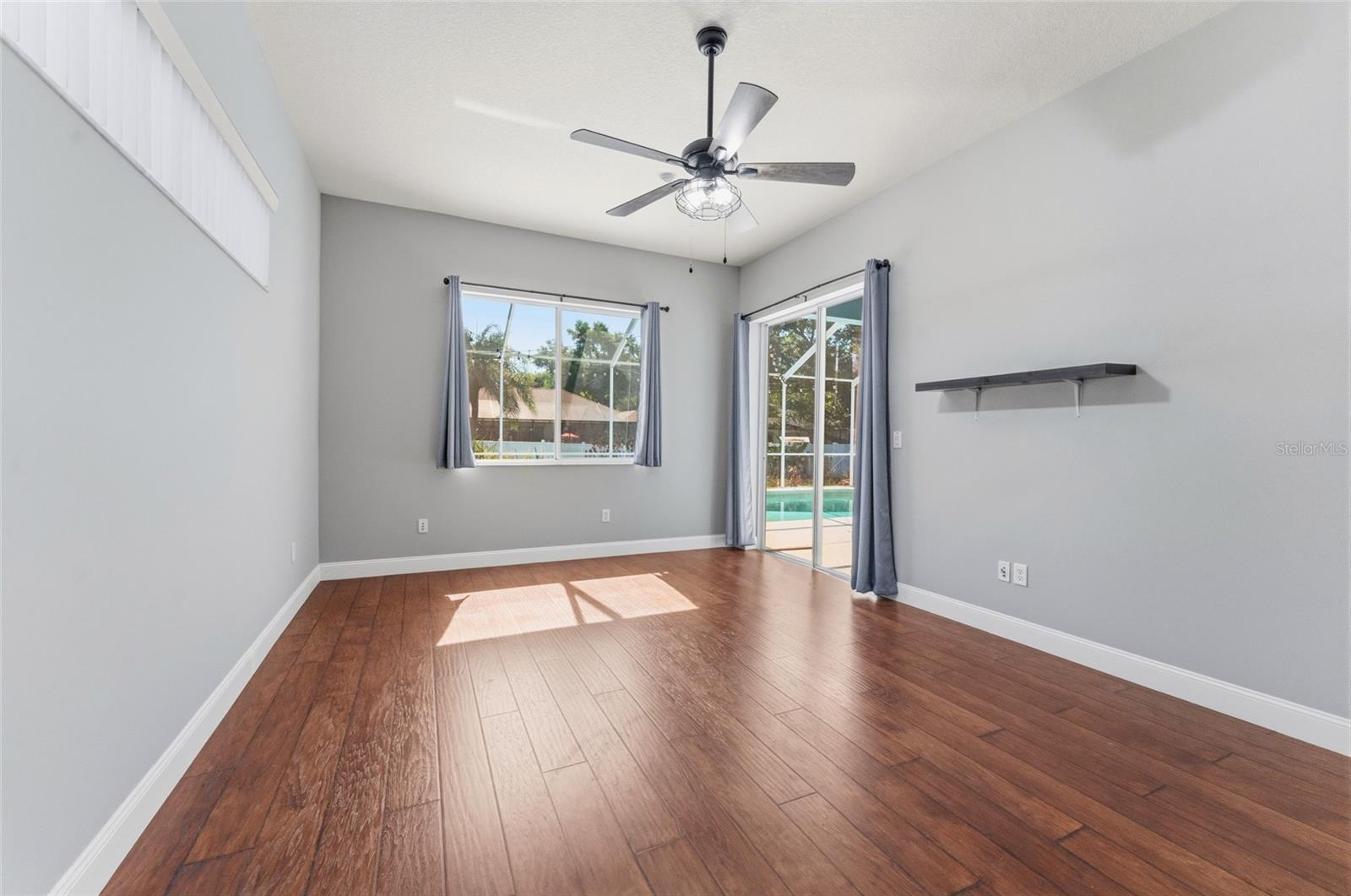Primary bedroom features sliding door to pool and lanai