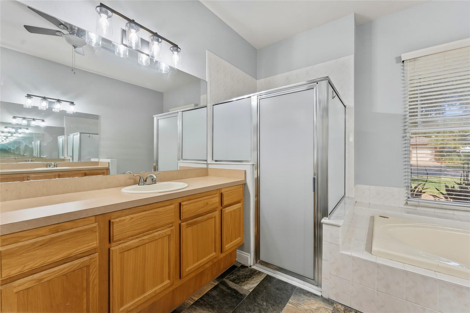Primary bath with tile walk-in shower and separate tub
