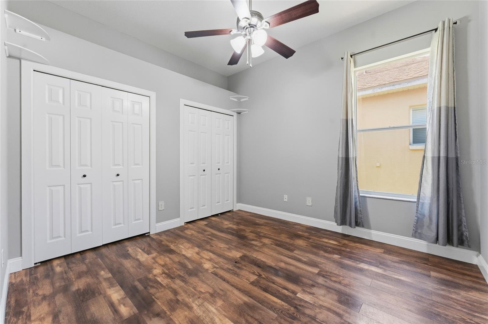 Bedroom 2 with dual closets and ceiling fan