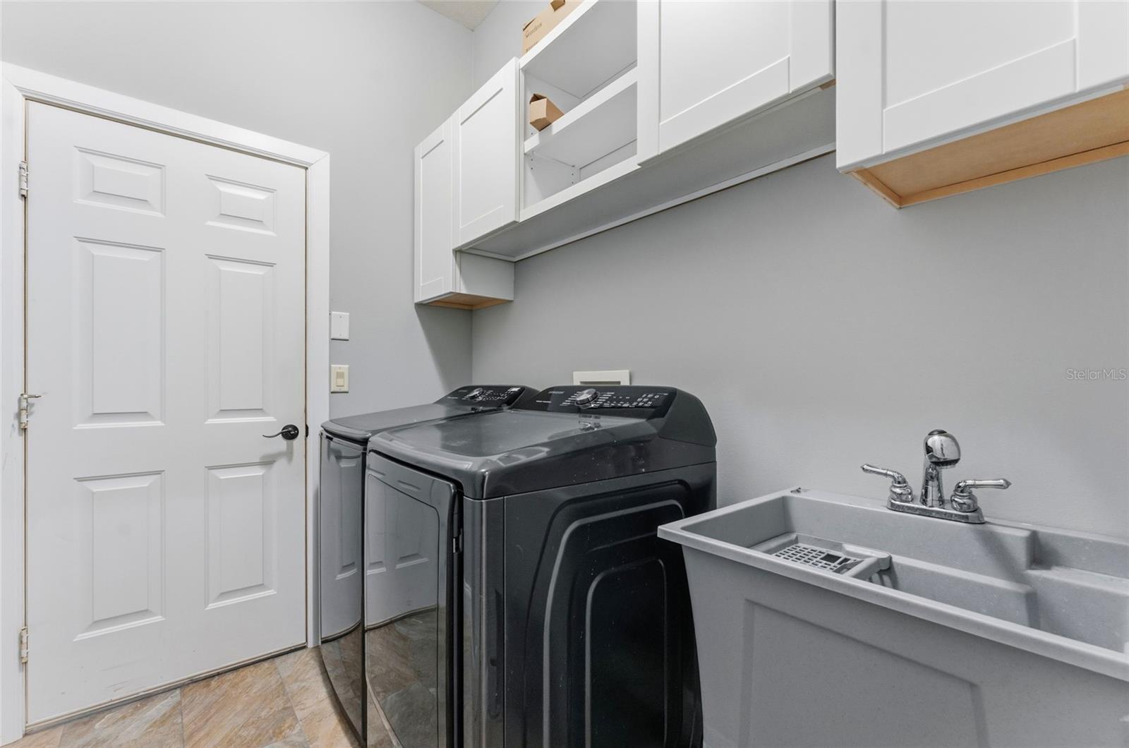 Laundry room with utility sink and additional storage
