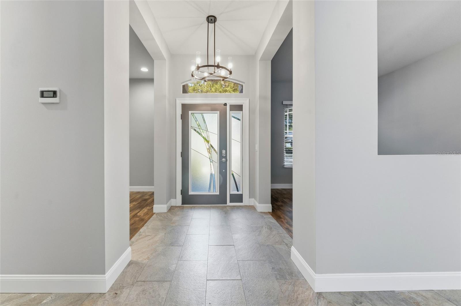 The custom glass door opens to high ceilings and a spacious foyer