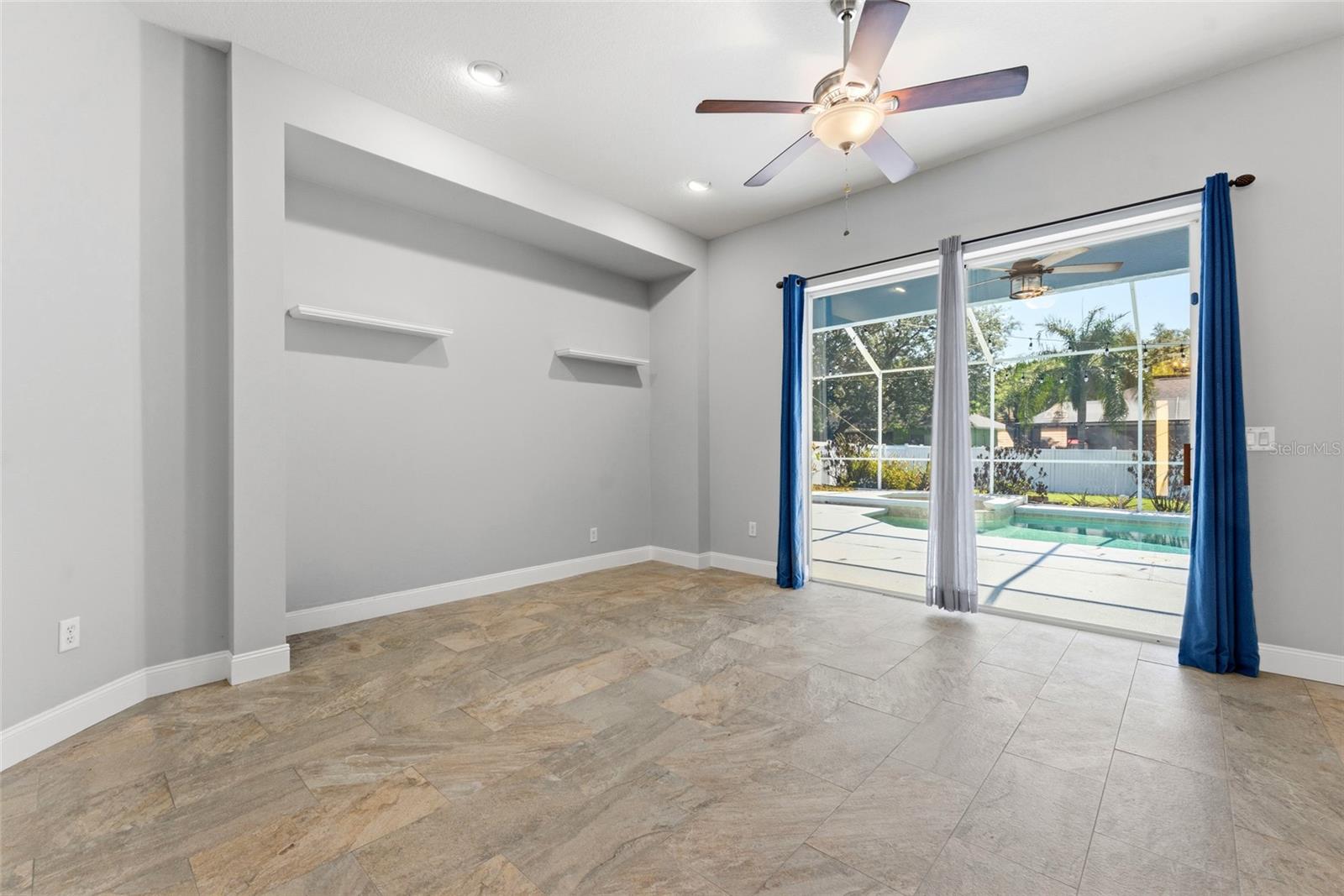 Living room with glass sliders leading to the screened in pool and lanai