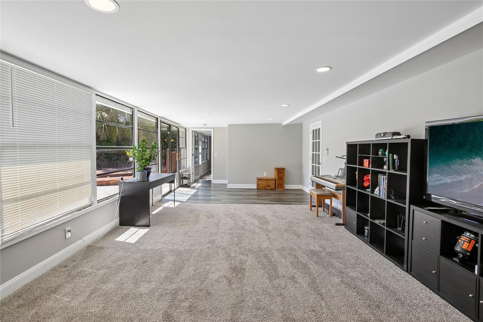 Bonus Room Alternate View - An alternate view highlights the room’s generous size, abundant natural light, and easy access to the adjacent poolside area. The open layout provides plenty of room for recreation, hobbies, or entertaining.