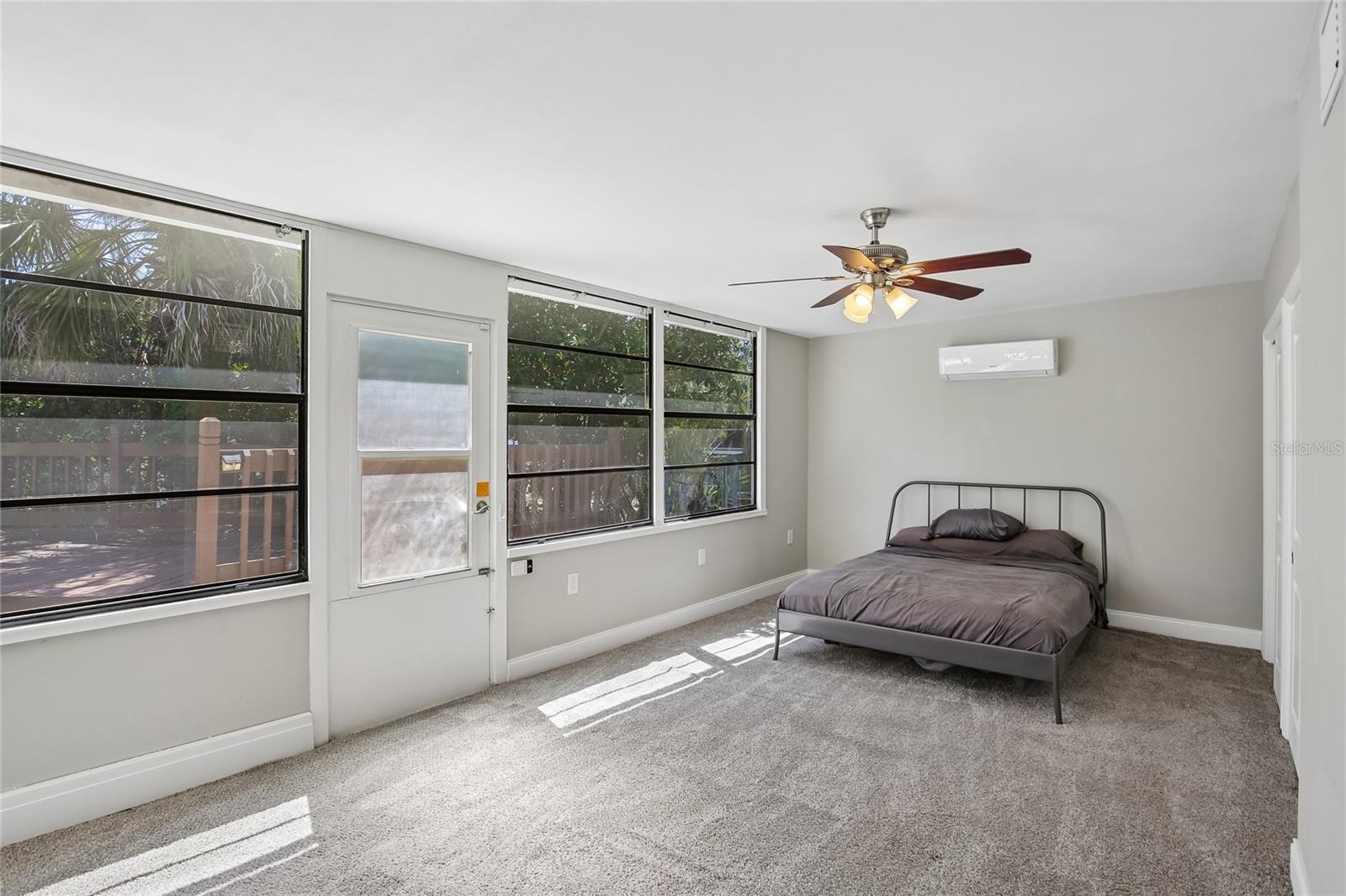 Fourth Bedroom with Poolside Windows - This bright fourth bedroom features a long wall of windows that brings in abundant natural light and creates an open, airy feel. Its location adjacent to the poolside bonus room adds convenience and versatility.