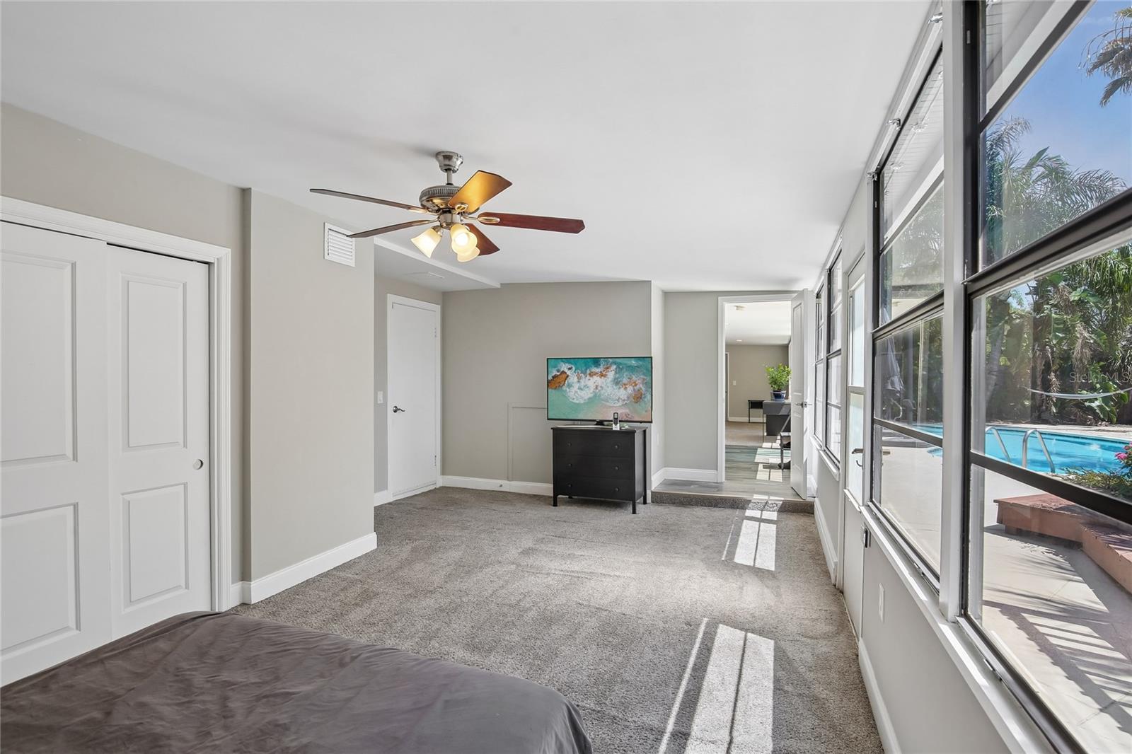 Fourth Bedroom Alternate View - An alternate view highlights the room’s generous size, neutral finishes, and easy connection to the surrounding bonus and poolside areas. The layout offers plenty of room for bedroom furniture while still feeling open and comfortable.