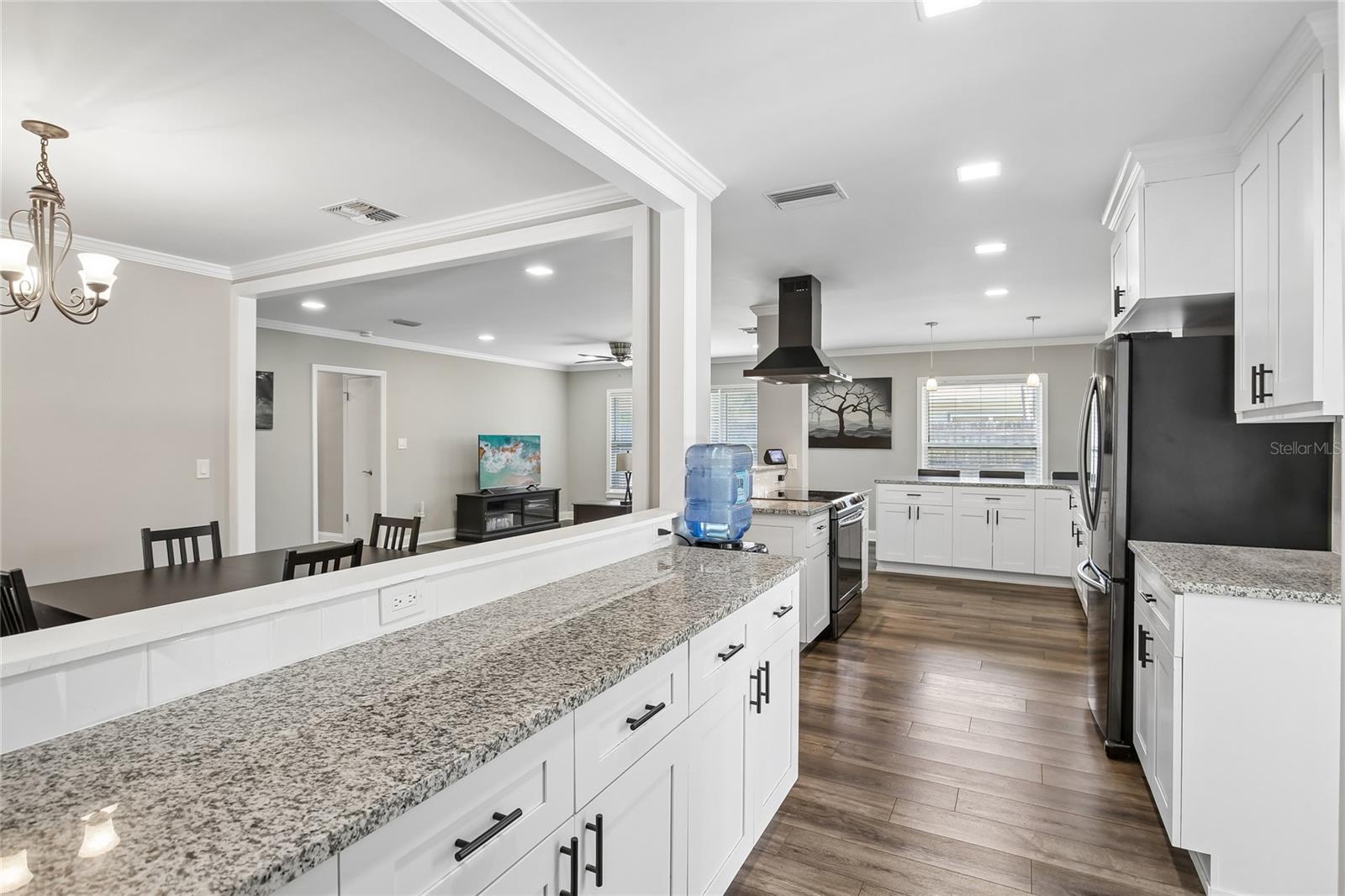 Kitchen Pass-Through Counter – A long granite pass-through counter provides additional prep space and an easy connection between the kitchen and adjacent dining area. Recessed lighting, crown molding, and updated finishes create a bright, cohesive look.