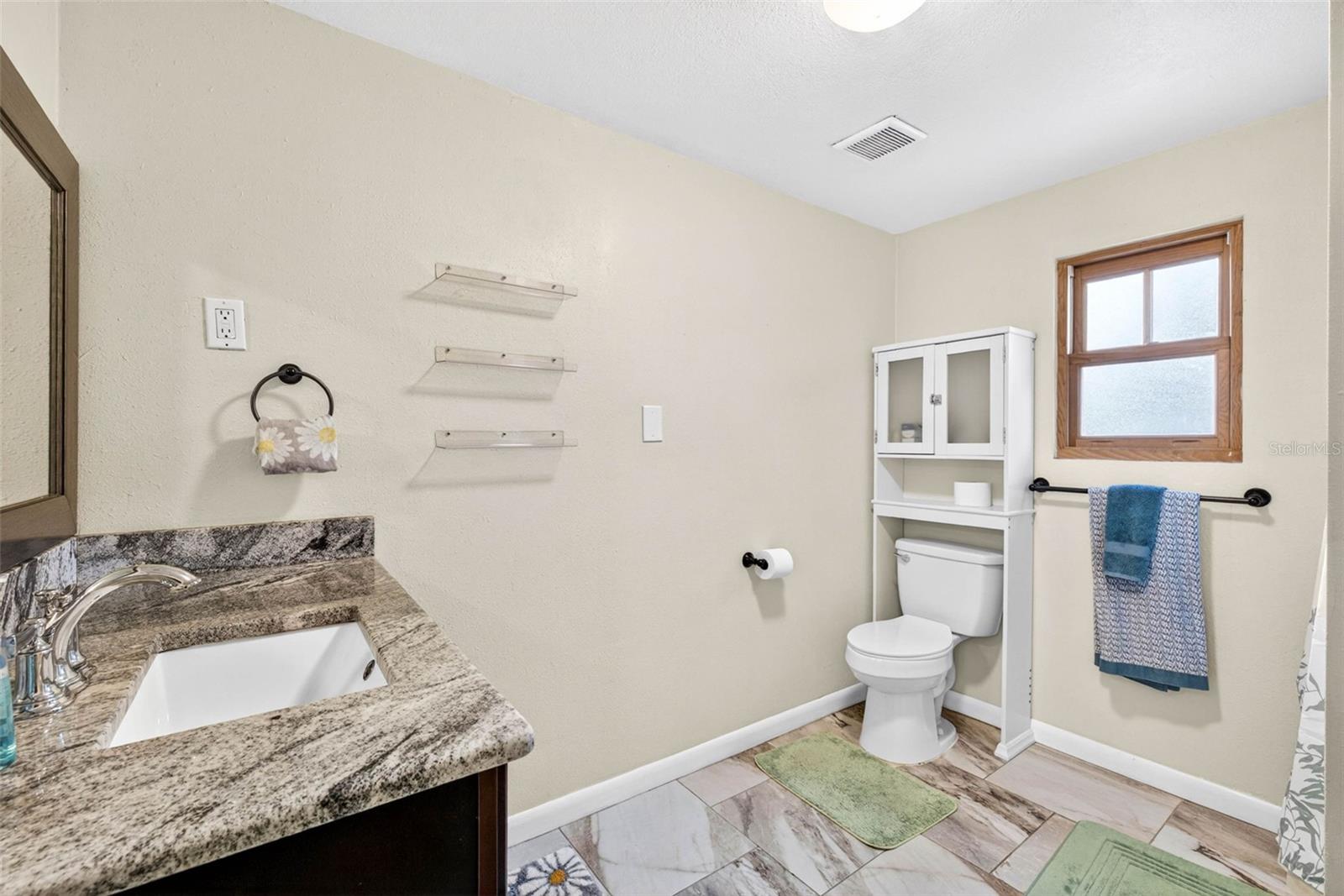 Guest bathroom with granite single vanity and shower tub combo