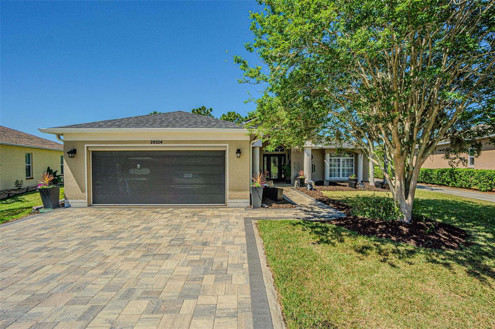 Pavers and an electric roll-down garage door screen.