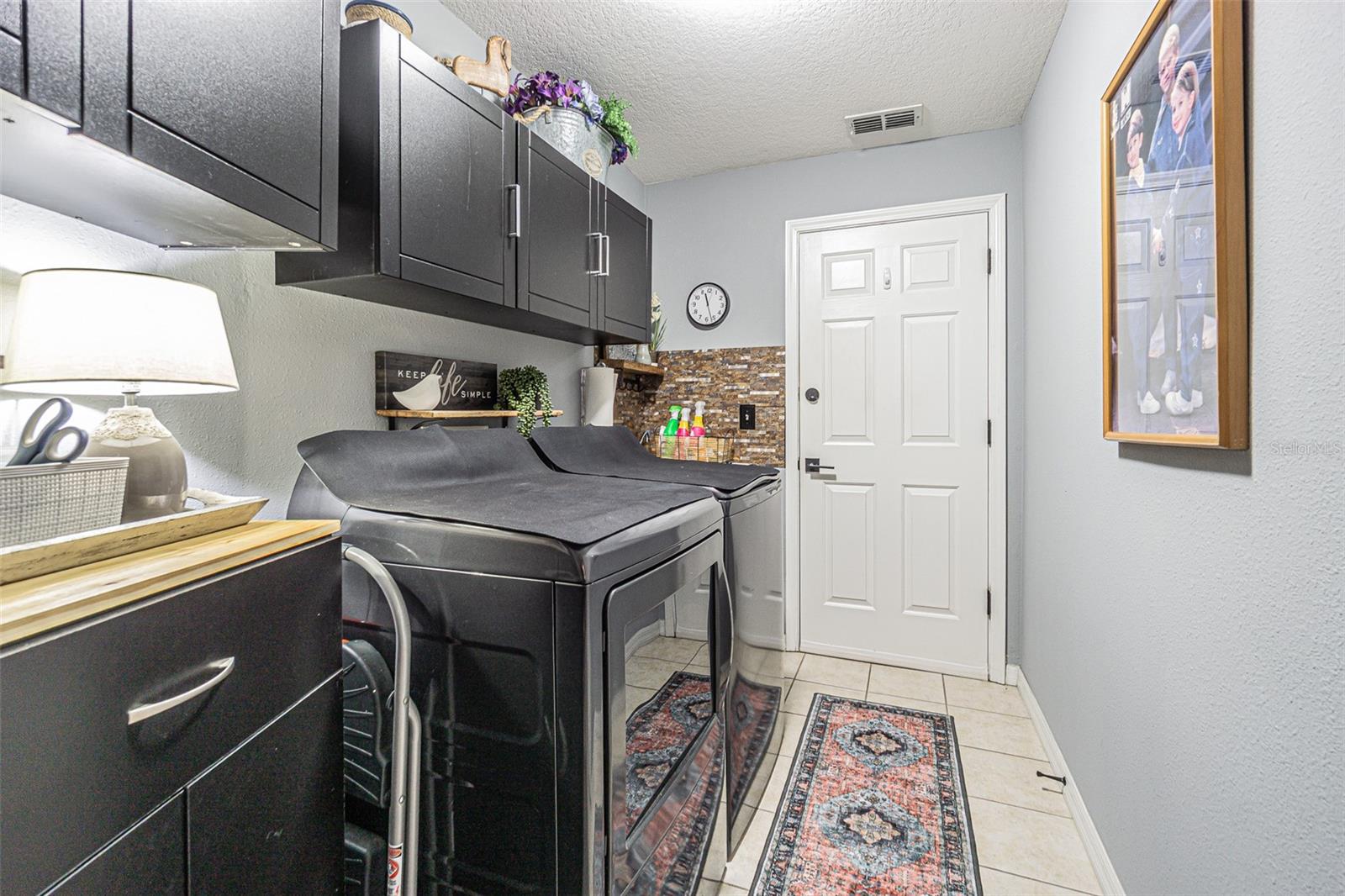Inside laundry room with storage
