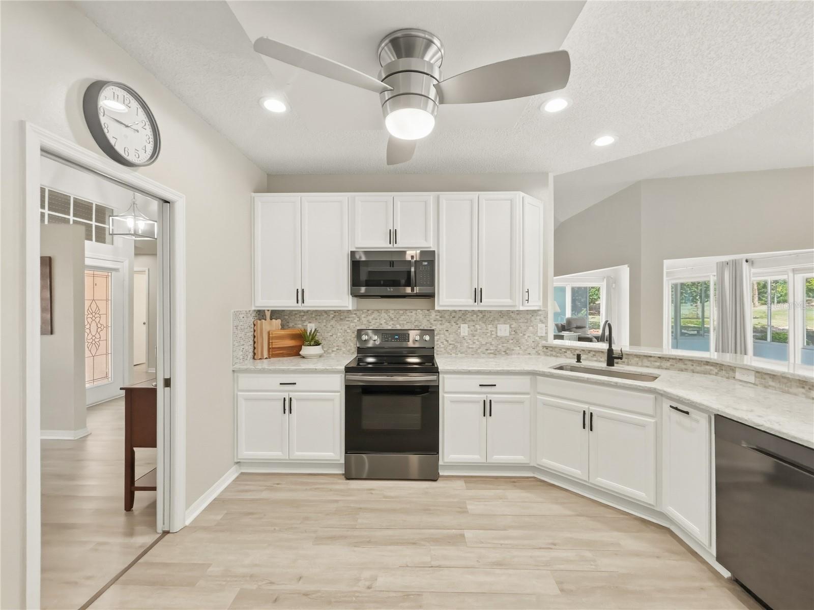 Any chef's delight! This kitchen has modern cabinetry, granite counters, tiled backsplash and gently used appliances