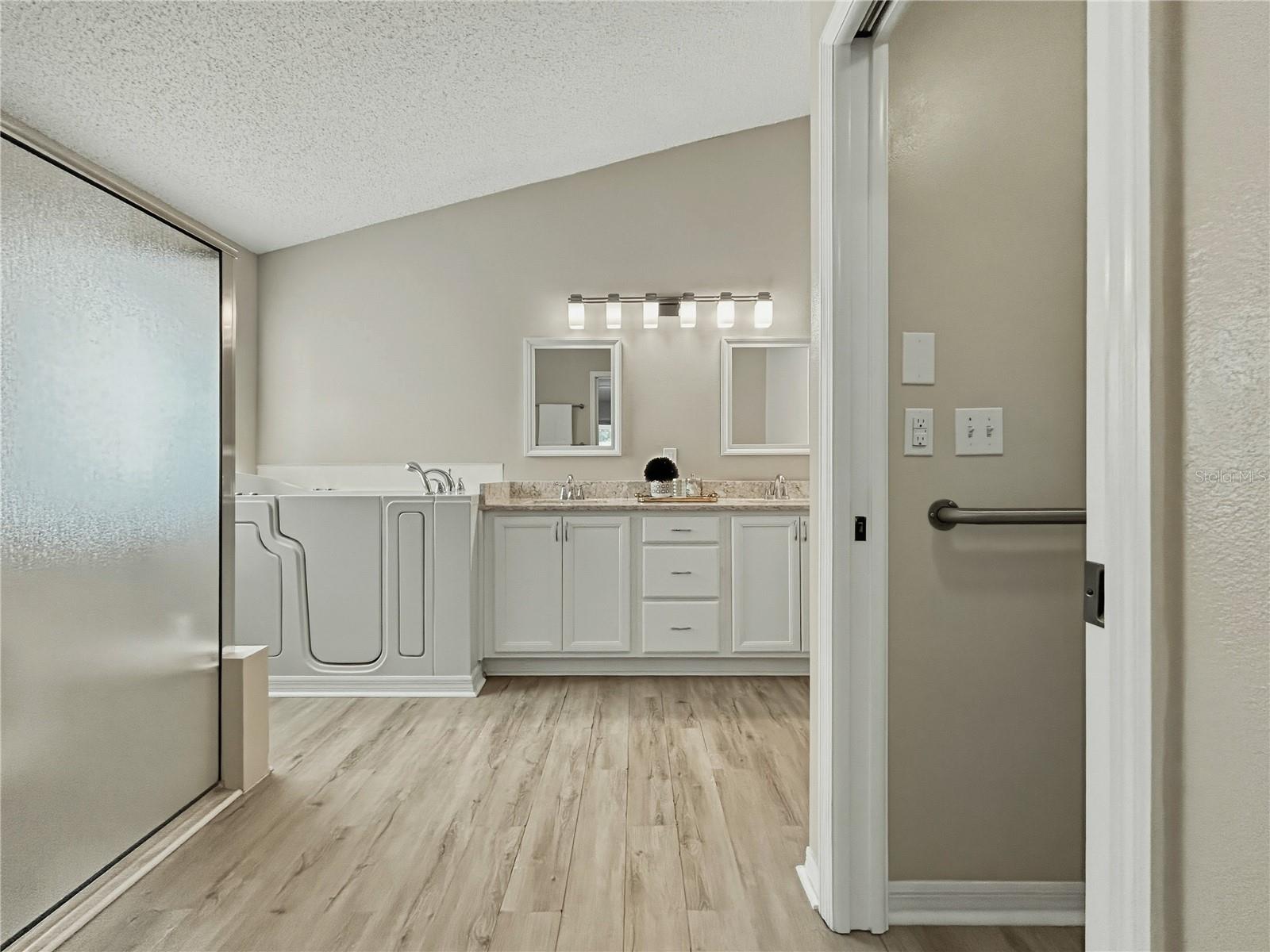 Enjoy the Safe Step Walk-In tub, modern cabinets, lighting and granite.